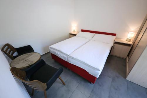 a bedroom with a bed and a table and a chair at Apartmány Vír in Vír