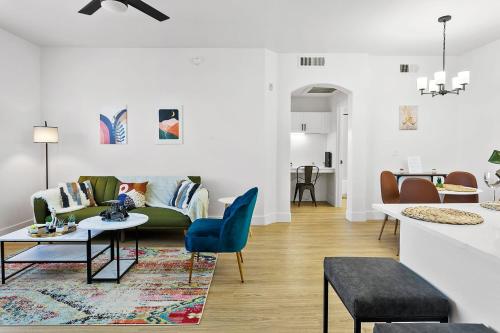 a living room with a green couch and a table at CozySuites Glendale by the stadium with pool 05 in Glendale
