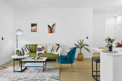 a living room with a green couch and a table at CozySuites Glendale by the stadium with pool 03 in Glendale