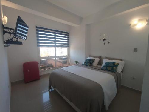 a bedroom with a large bed with a window at Ocean Blue in Porlamar