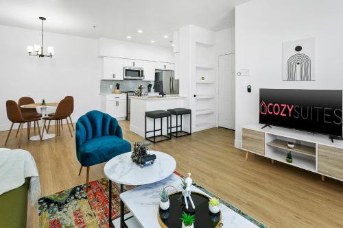 a living room with a couch and a tv and a table at CozySuites Glendale by the stadium with pool 01 in Glendale