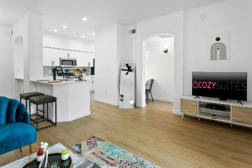 a living room with a blue couch and a kitchen at CozySuites Glendale by the stadium with pool 04 in Glendale