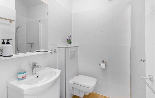 a white bathroom with a toilet and a sink at 2 Bedroom Cozy Home In Jaroslawiec in Jarosławiec