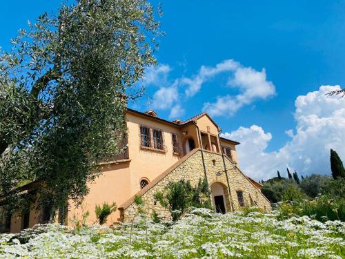 um edifício com flores em frente em Villa Cresci con piscina em Sassetta