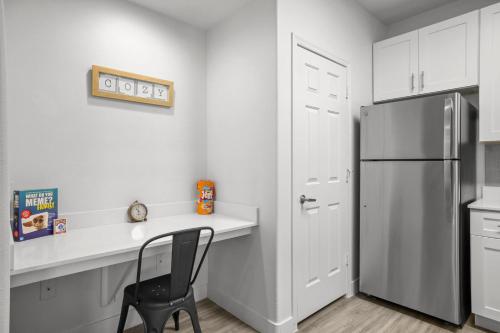 a kitchen with a black refrigerator and a black chair at CozySuites Modern Urban in Historic Glendale in Glendale