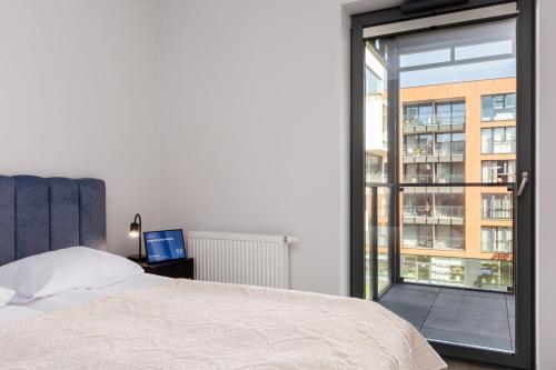 a bedroom with a bed and a large window at Apartamenty Svager in Gdańsk