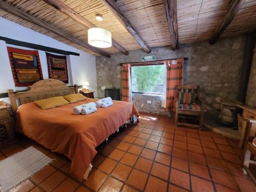 a bedroom with a large bed with towels on it at Cabañas Malka in Tilcara