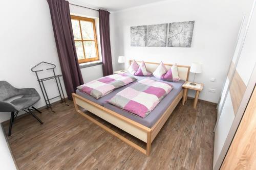 Schlafzimmer mit einem Bett mit rosa und weißen Kissen in der Unterkunft Iris in Walsdorf