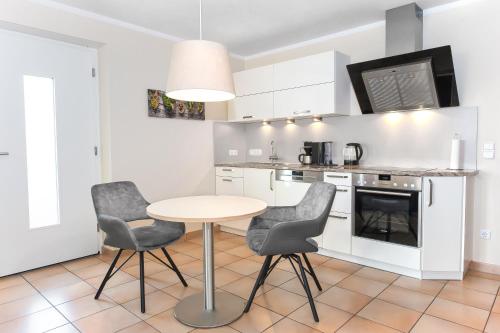 uma cozinha com mesa e cadeiras num quarto em Iris em Walsdorf