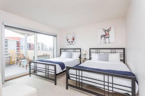 two beds in a bedroom with a balcony at Upscale 3BR Penthouse by CozySuites in Indianapolis