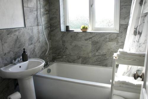 ein Badezimmer mit einer weißen Badewanne, einem Waschbecken und einer Badewanne in der Unterkunft Middleton, Manchester in Middleton