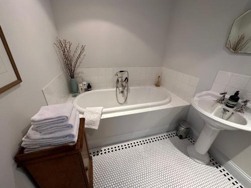 a white bathroom with a tub and a sink at Greenhill Farm Barn B&B in Sutton under Brailes