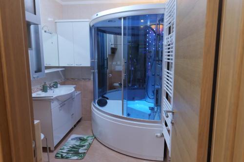 a bathroom with a shower with a blue tub at Apartman Tina ***** s jacuzzijem u blizini Parka prirode Papuk in Slatina