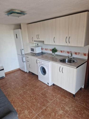 een keuken met een wastafel en een wasmachine bij Apartamento Malaga Aeropuerto in Cártama