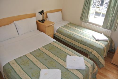 倫敦的住宿－貝爾格羅夫酒店，酒店客房设有两张床和窗户。