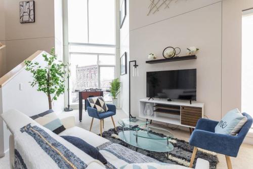 インディアナポリスにあるTWO Modern Penthouses on Mass by CozySuitesのソファとテレビのあるリビングルーム