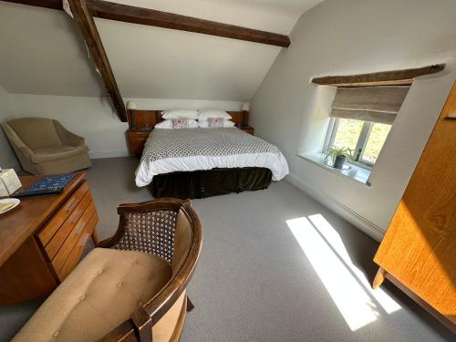 um quarto com uma cama e uma cadeira num quarto em Greenhill Farm Barn B&B em Sutton under Brailes