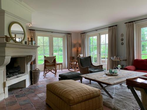 a living room with a fireplace and a table at Lovely warm Country home in Breukeleveen