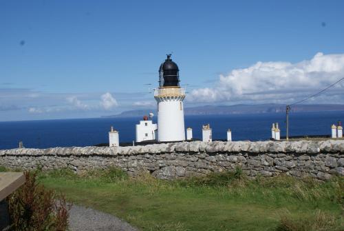 a lighthouse sitting on top of a stone wall at The Mey Hotel in Mey