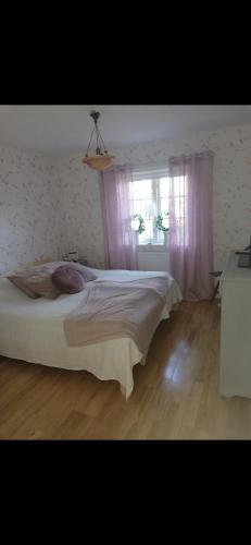une chambre avec un grand lit et une fenêtre dans l'établissement Eskilsäter Byn Säffle, à Säffle