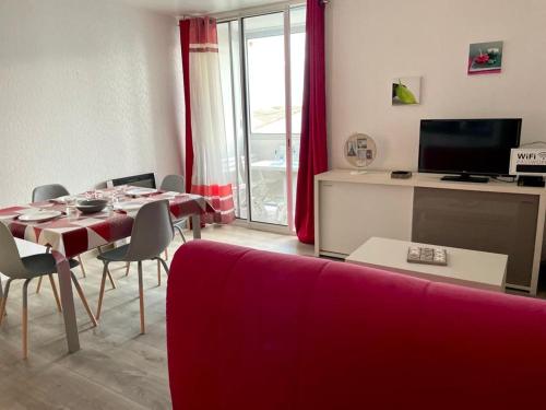 ein Wohnzimmer mit einem roten Sofa und einem Tisch in der Unterkunft BUBBLE GOM'Z in Saint-Hilaire-de-Riez