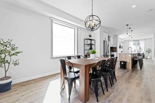 a kitchen and dining room with a wooden table and chairs at Modern Luxury Home - King Bed•Arcade•WEM•A/C in Edmonton