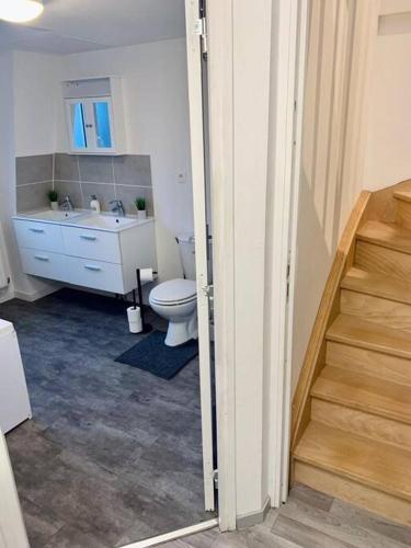 La salle de bains est pourvue de toilettes, d'un lavabo et d'un escalier. dans l'établissement Maison 3 chambres - 600m Métro Marbrerie - Lille, à Mons-en-Baroeul