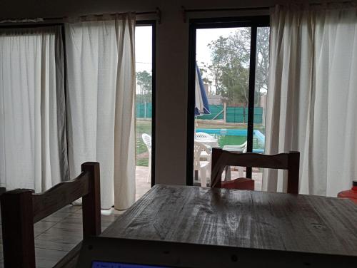 a dining room table with a view of a pool at Rincón Joven II in San Miguel del Monte