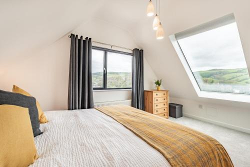 sypialnia z łóżkiem i dużym oknem w obiekcie Beach View w mieście Ilfracombe
