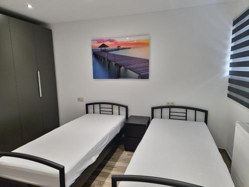 two twin beds in a room with a pier at le coin douillet in Saint-Ghislain