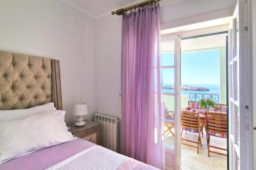 a bedroom with a bed and a balcony with a table at Montesan Luxury Apartment DOO ODMONTE in Sveti Stefan