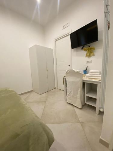 a bedroom with a desk and a tv on the wall at DIMORA DEL CARMINE in Bari
