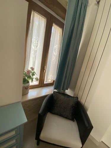 a chair sitting in a room with two windows at DIMORA DEL CARMINE in Bari