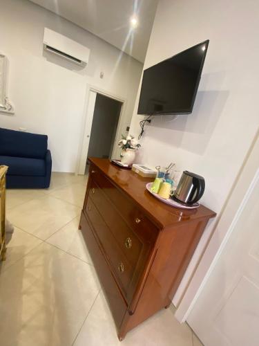 a living room with a desk with a tv on the wall at DIMORA DEL CARMINE in Bari