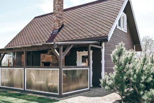 een huis met een afgeschermde veranda met een dak bij VERTIKĀLES in Liepāja