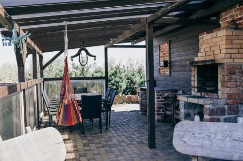 un patio con mesa, sillas y chimenea en VERTIKĀLES, en Liepāja