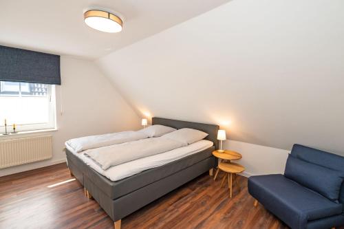 BojendorfにあるBackhaus-Wohnung-3のベッドルーム1室(ベッド1台、青い椅子付)