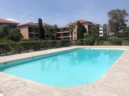 une grande piscine bleue devant un immeuble dans l'établissement 2025 - grand studio avec piscine et plage à 50 m, à San-Nicolao