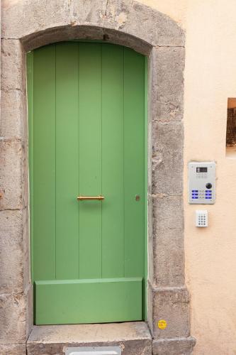 une porte verte dans un mur de pierre avec un compteur dans l'établissement le Roche, à Toulon