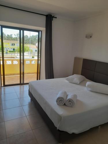 1 dormitorio con 1 cama con 2 toallas en Flor de Sal, en Vila Real de Santo António