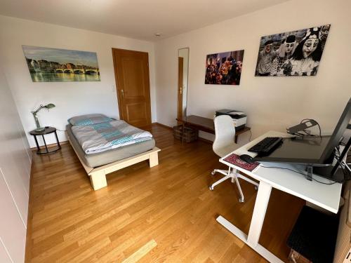 Habitación con cama y escritorio con ordenador. en Ferienappartment mit Homeoffice, 2 Schlafzimmer mit Einzelbetten, en Weil am Rhein
