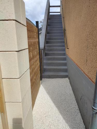 a stairway leading up to a building with a staircase at Appartement neuf avec jardin privatif in Périgueux