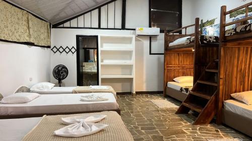 a room with three bunk beds and a ladder at Monte Verde Hostal in El Zaino