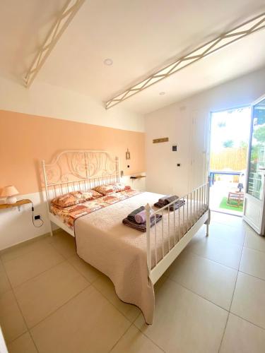 um quarto com uma cama grande e uma janela grande em Villa Elisa em Minturno