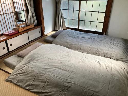 1 dormitorio con 2 camas y 2 ventanas en Zushi - House - Vacation STAY 14472, en Zushi