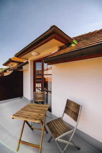 two chairs and a wooden table on a patio at Kounický dvůr in Dolní Kounice