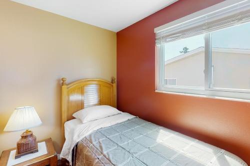 a small bedroom with a bed and a window at Dune Our Thing in Rotonda West