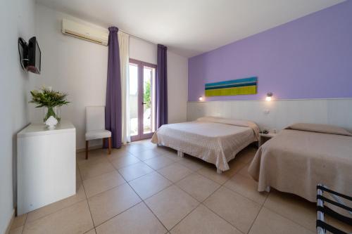 um quarto de hotel com duas camas e uma janela em Corte dei Melograni Hotel Resort em Otranto