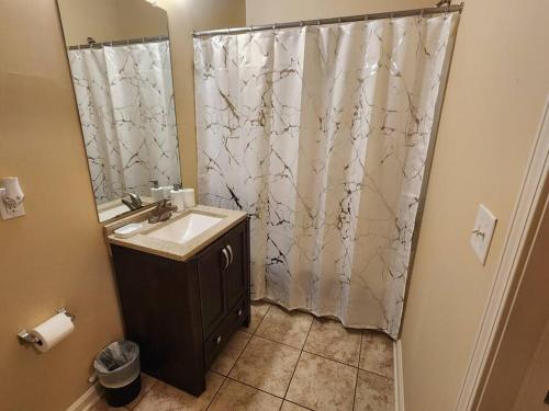 a bathroom with a sink and a shower curtain at Adorable apartment w/ pool view in Charlotte