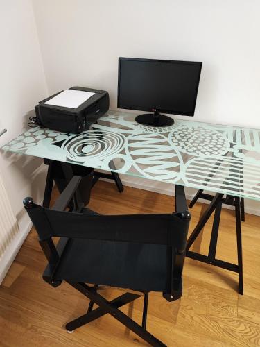 a glass table with a computer on top of it at La Casa di Priscilla in Fagagna